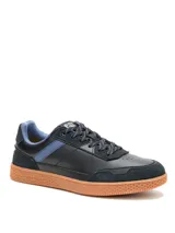 Championes Cat modelo Pause Retro, de diseño urbano con capellada combinada en cuero napa y gamuza en color negro. Presenta detalles en azul en los laterales y el interior, cordones estampados y una suela de goma color caramelo con textura de panal.