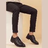 Zapato de vestir tipo brogue con cordones, confeccionado en cuero vacuno con textura granulada. Presenta detalles de perforaciones decorativas en la puntera y laterales, con suela de goma resistente.