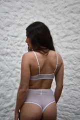 Top de microtul y encaje color blanco, de copas triangulares sin aro ni relleno, con tirantes finos regulables y banda elástica en la base.