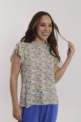 Blusa estampada con flores pequeñas en tonos amarillos, azules y grises. Presenta cuello alto fruncido y mangas cortas con volados.