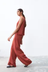 Pantalón palazzo color ladrillo, de tiro alto y corte holgado.