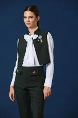 Chaleco de corte sastrero en color verde oscuro, con diseño estructurado, cuello mao y cierre frontal.