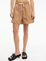 Short de tiro medio/alto color camel, con pretina elástica fruncida y lazo ajustable de cordón blanco. El corte es holgado y el ruedo ligeramente curvo.