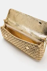 Bolso tipo sobre con diseño trenzado en color dorado. Cuenta con asa de mano fija, asa bandolera extraíble, bolsillo interior y cierre mediante solapa con imán.