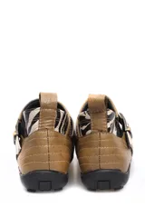 Bota baja de cuero color marrón, estilo botín con elásticos laterales y tira con hebilla metálica ajustable. Cuenta con costuras decorativas pespunteadas y suela de goma con relieve.