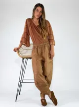 Pantalón de lino color amarillo mostaza, de corte bombacho y relajado, con bolsillos delanteros aplicados y cintura elástica.