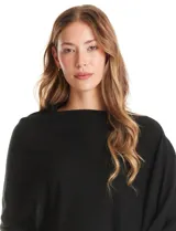 Poncho tejido de punto con diseño asimétrico y aberturas laterales para los brazos.