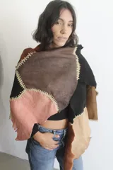 Ruana artesanal confeccionada con piezas de napalán unidas mediante técnica de crochet, con diseño de parches en tonos tierra y texturas de piel sintética.