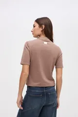 Remera de manga corta con cuello polera, confeccionada en tejido de textura diferenciada y calce ajustado al cuerpo.