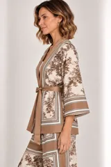 Kimono de seda liviano con estampa estilo toile de Jouy en tonos marrones y beige, con detalles de guardas geométricas, mangas tres cuartos anchas, bolsillos laterales y lazo para ajustar en la cintura.