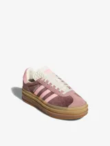 Zapatillas Adidas Gazelle Bold con plataforma, capellada de terciopelo color marrón y rosa, con las tres tiras laterales en rosa claro y suela de goma color caramelo.