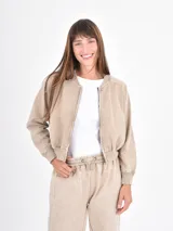 Campera tipo bomber de corte cropped, con cierre frontal, cuello redondo y puños elásticos, confeccionada en tela con efecto lavado.