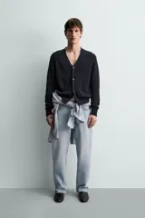 Cárdigan de punto relaxed fit confeccionado en mezcla de algodón y lino, en color azul marino. Presenta cuello en V, manga larga, bolsillos delanteros de plastrón, acabados en rib y cierre frontal con botones.