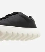 Championes casuales de hombre con diseño minimalista, confeccionados en poliuretano con acabado liso. Presentan cierre mediante cordones y una suela bold voluminosa de color blanco.