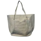Cartera tipo tote de cuero sintético con textura granulada, color gris claro, con doble asa de hombro y bolsillo frontal abierto.
