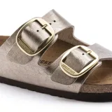 Sandalias Birkenstock modelo Arizona Big Buckle, con dos correas anchas en color taupe metalizado y hebillas grandes doradas. Presenta plantilla anatómica de corcho y suela de goma.
