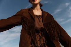 Chaqueta marrón de cuero gamuzado con flecos en la parte delantera y trasera.