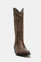Bota estilo cowboy de piel con efecto desgastado. Presenta bordados decorativos en el cuerpo, doble tirador lateral y tacón medio con acabado en punta.
