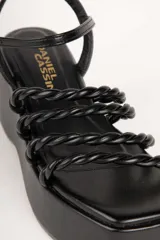 Sandalias de plataforma color blanco con tiras trenzadas y pulsera al tobillo.