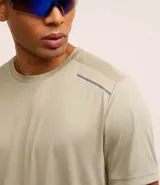 Remera deportiva de hombre con tecnología Dry, cuello redondo y mangas cortas. Presenta un diseño con estampa sutil tipo heat print y detalles de líneas en los hombros.