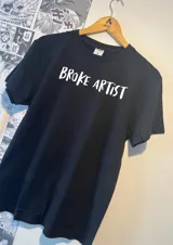 Remera negra de algodón con estampado frontal en color blanco con la frase "Broke Artist".