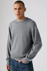 Sweater de tejido de punto gris jaspeado, con cuello redondo, mangas largas y puños y ruedo acanalados. Presenta el logo de la marca bordado en pequeño en el pecho.