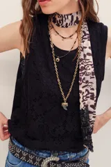Musculosa negra de encaje con cuello redondo y diseño sin mangas, de corte holgado.