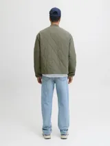 Campera acolchada tipo liner color verde oliva, con cuello estilo baseball, cierre frontal con botones a presión, bolsillos laterales y bolsillo en el pecho con etiqueta de marca.