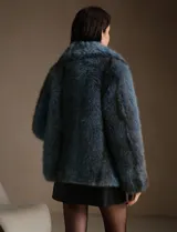 Tapado de piel sintética en color azul, con cuello amplio y silueta relajada de largo medio.