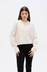 Sweater de tejido de punto color natural, con cuello redondo, diseño holgado y mangas largas con puños acanalados.