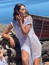 Vestido de playa blanco de crochet con aberturas laterales.
