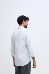 Camisa de manga larga fit semi slim color celeste, con cierre frontal de botones y cuello camisero clásico.