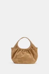 Bolso de hombro formato mini shopper confeccionado en piel de ante, con diseño fruncido, doble asa de mano y cierre mediante clip metálico.