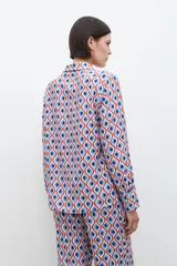 Camisa de manga larga con cuello clásico y estampa geométrica retro en tonos azul, rojo y blanco.