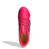 Championes de fútbol Adidas Predator Club para terreno firme, con diseño en color fucsia y blanco, destacando las tres tiras laterales en negro y detalles en amarillo neón.
