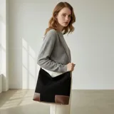 Bolso tipo hobo grande de eco cuero con textura símil gamuza color bordó, con refuerzos en la base y detalles en eco cuero marrón claro en las esquinas inferiores y tiras.