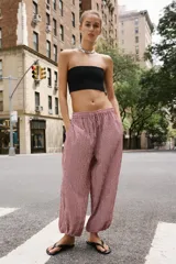 Pantalón bombacho con estampado de cuadros vichy en color rojo y blanco, cintura elástica con cordón de ajuste y puños elásticos en los tobillos.