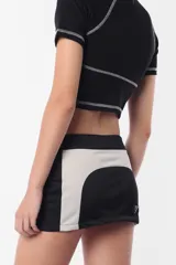 Remera corta color lila con cuello alto, mangas cortas y costuras a la vista.