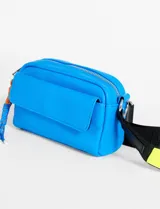 Bandolera mini color amarillo pastel, con bolsillo frontal y correa de cinta negra regulable.