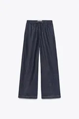 Pantalón de jean de tiro alto con corte de pierna ancha, cintura elástica con cordón ajustable y bolsillos laterales.