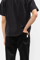 Pantalón de pana negro con cintura elástica y cordón de algodón. Cuenta con bolsillos laterales, un bolsillo trasero y el parche característico de Polonio.