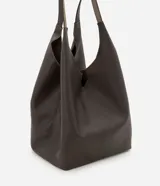 Cartera hobo grande marca Satinato, confeccionada en cuero con textura natural y color marrón oscuro. Presenta un diseño amplio y suave de estilo contemporáneo, con asas de hombro integradas y cierre interno con mosquetón.