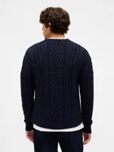 Buzo de tejido de punto con diseño de trenzas verticales, cuello redondo y puños y ruedo acanalados.