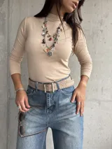 Polera de cuello alto y manga larga, confeccionada en tejido de algodón con textura acanalada y ajuste al cuerpo.