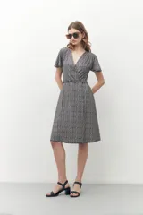 Vestido midi con estampado geométrico en blanco y negro, corte cruzado, mangas cortas y escote en V.