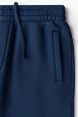 Pantalón deportivo azul marino confeccionado en felpa de mezcla de algodón, con cintura elástica ajustable, bolsillos laterales y bajos con elástico fruncido.