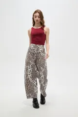 Pantalon tipo jean de corte barrel y tiro bajo, con estampado animal print de leopardo en tonos marrones y blancos.