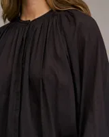 Camisa fluida color crema con rayas verticales, cuello mao, mangas largas abullonadas y puños elásticos.