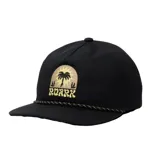 Gorra Roark Venture color negro con visera chata, cordón decorativo sobre la visera y parche bordado frontal con diseño de palmera y sol.