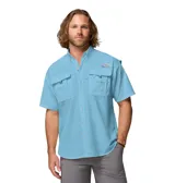Camisa de manga corta Columbia modelo Bahama II S/S Shirt, color celeste, de ajuste relajado y tejido de nailon de secado rápido. Cuenta con cuello abotonado, bolsillos frontales con solapa, presilla para caña de pescar y ventilación en la espalda con forro de malla.